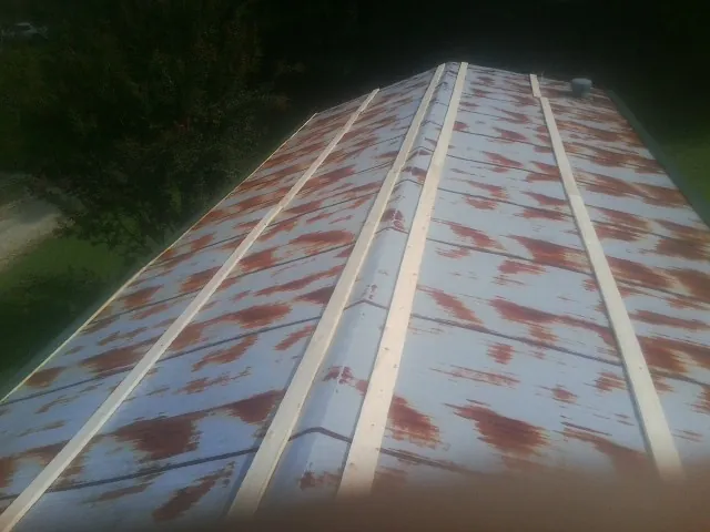 Rusted metal roof panels with new wood purlins before replacement — Storm Damage Roof Repair in Grantville by Roofing Brothers