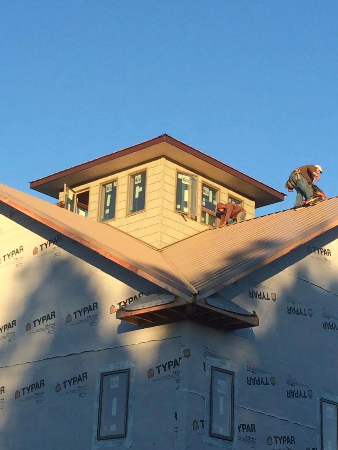 Roofers working around a rooftop cupola on a new metal roof at sunset — Roof Waterproofing in Grantville by Roofing Brothers